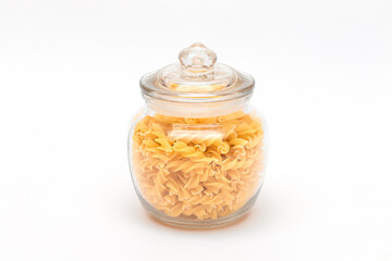 Uncooked Fusilli Pasta in Glass Jar on White Background. Raw and Dry Macaroni. Unhealthy and Fat Food. Italian Culture