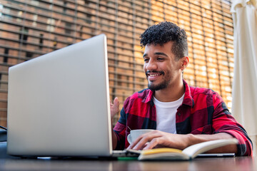 man smiles happy making video call from a terrace