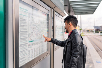 young man consulting the public transportation map