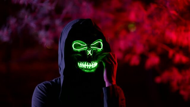 undead or spirit of death is beckoning in night, person in Halloween suit with skull mask