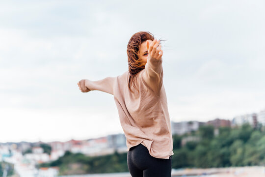 middle-aged young woman with open arms, breathing air looking at camera in a complicit way. mental health care concept