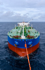 Crude oil transfer operation from floating storage of oil tanker to the export oil tanker using tandem mooring setup operation in open sea.