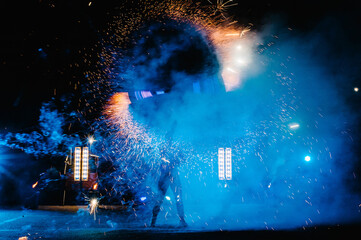 Fire show, dancing with flame, male master juggling with fireworks, performance outdoors, draws a...