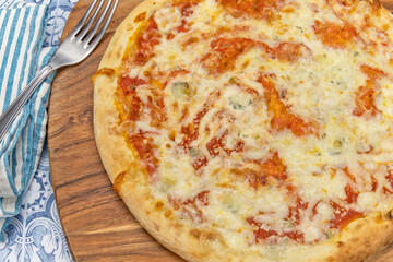 Pizza italienne fraîche entière avec des tomates sur une planche de bois