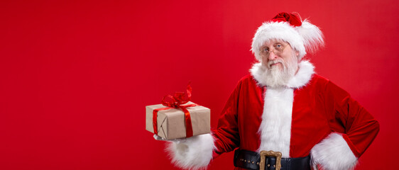 Banner real funny Santa Claus with gift present box on hand on red studio background. Sale, Discount, Black Friday. Copyspace.