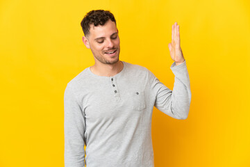 Young caucasian handsome man isolated on yellow background with tired and sick expression