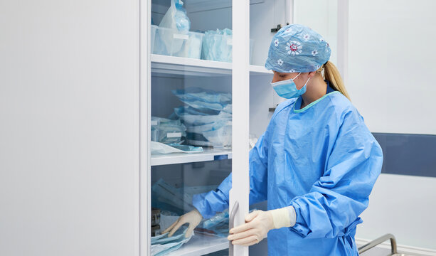Krankenschwester mit Mundschutz sucht Pflegehilfsmittel