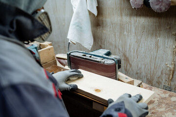 A joiner polishes the board. The process of processing boards in the carpentry workshop.