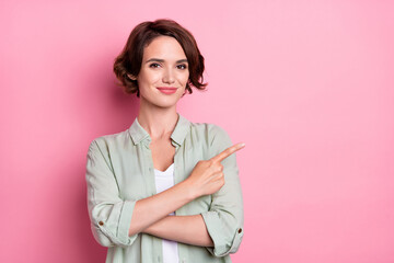 Portrait of attractive cheery content girl demonstrating copy blank space advert isolated over pastel pink color background