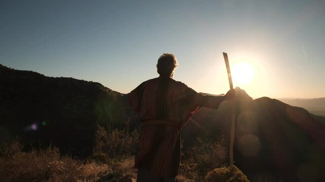 A Biblical prophet or holy man on a mountain top at sunset