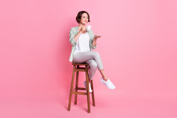 Full length photo of lovely bob hairdo millennial lady sit chair drink wear grey green outfit...