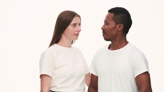 Smiling multinational couple looking to each other and giving positive answer
