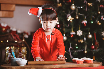 young girl making Santa cupcake for Christmas party at home