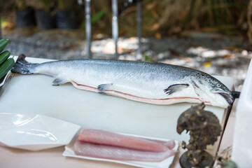Cut The salmon fillet in a fish shop. The salmon fillet for sashimi and sushi.