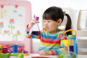 young girl playing color sorting and fine motor skill toy at home