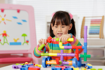 young girl playing water pipe construsction toy at home