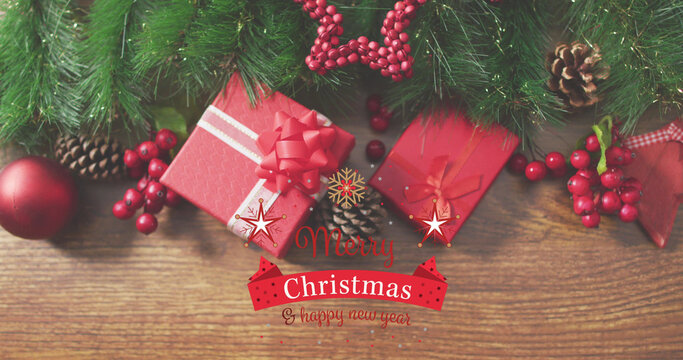 Image of merry christmas text over decorations on wooden background