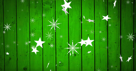 Image of christmas stars falling over green wooden background