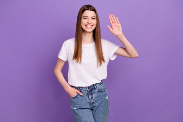 Portrait of attractive cheerful girl waving hi hello greetings isolated over bright purple violet color background © deagreez