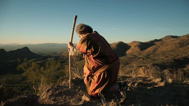 A Biblical prophet or holy man kneeling in prayer