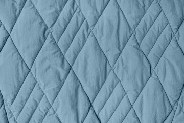 Fototapeta na wymiar Quilted fabric background. Blue texture blanket or puffer jacket