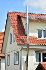 Schornstein, Außenkamin aus Edelstahl an der Fassade eines Wohnhauses