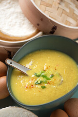 Green bowl with egg-drop soup or chinese traditional soup of wispy beaten eggs in chicken broth, middle closeup, vertical shot