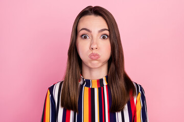 Photo of adorable playful young lady wear striped shirt big eyes bloated cheeks isolated pink color...