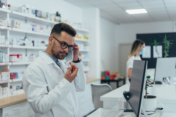 Pharmacist with protective mask on his face while working at a pharmacy