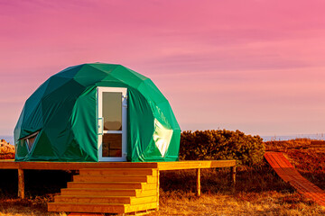 Green glamping on the Pacific Ocean at sunset. Kamchatka Peninsula