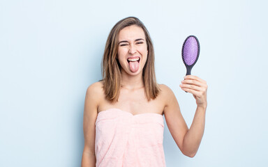 young pretty woman with cheerful and rebellious attitude, joking and sticking tongue out. hairbrush...