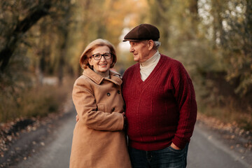 Fototapeta premium Senior married couple dancing in autumn park, celebrating anniversary, petting. Happy old age