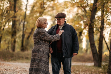 Senior married couple dancing in autumn park, celebrating anniversary, petting. Happy old age