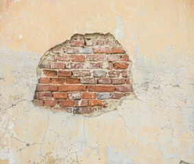 Damaged Brick wall. Broken plaster with cracks. Decoration and background element. Detail of house and hole in old building.