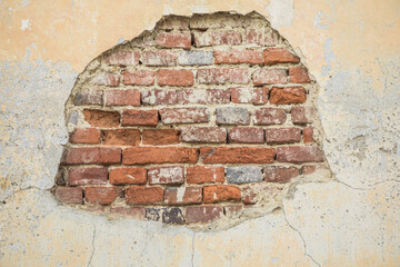 Damaged Brick wall. Broken plaster with cracks. Decoration and background element. Detail of house...