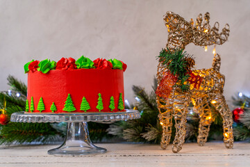 Christmas cake decorated with Christmas trees. Deer with a flashing Christmas garland. Decoration for the holiday. Beautifully served table for the celebration. Copy space.