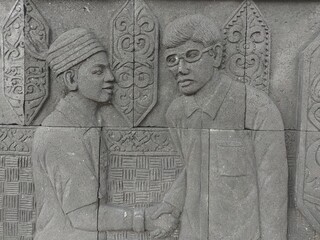 Reliefs of the life of the indigenous people of Kalimantan shaking hands on the walls of Central Park, North Penajam Paser Regency
