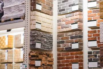 Exhibition showing samples of decorative stone tiles of different colors on the shelves of the store's warehouse.
