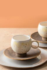 Handmade ceramic tableweare set cup and plate on beige  baclground. Copy space