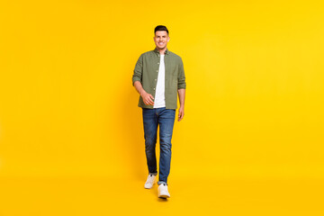 Naklejka premium Full length body size photo guy walking forward isolated vibrant yellow color background