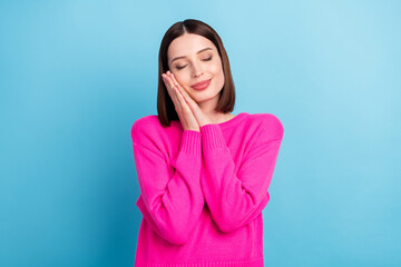 Photo of dreamy sweet young woman dressed pink sweater arms cheek closed eyes isolated blue color background