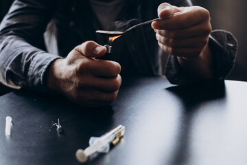 Drug addicted man heating heroin on spoon