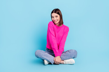 Portrait of attractive shy cheerful girl sitting posing shopping day isolated over bright blue color background