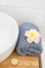 White Sink Gray Towell Candle Plumeria Flower SPA at Home Concept Vertical