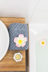 White Sink Gray Towell Candle Plumeria Flower SPA at Home Concept Vertical Top View