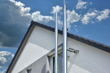 Schornstein, Außenkamin aus Edelstahl an der Fassade eines Wohnhauses