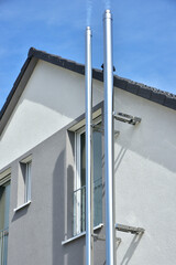 Schornstein, Außenkamin aus Edelstahl an der Fassade eines Wohngebäudes