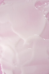 A vertical shot of a wet pink surface lotion