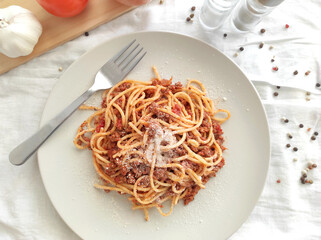 Spaghetti Bolognese with minced beef, onion, chopped tomato, garlic, olive oil, stock cube, tomato puree and Italian herb. Traditional Italian food on a plate.