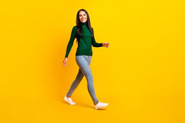 Fototapeta na wymiar Full size profile side photo of young positive happy smiling girl in green sweater go walk isolated on yellow color background
